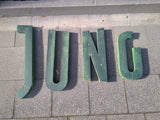 Schriftzug "JUNG"aus grünen Metallbuchstaben