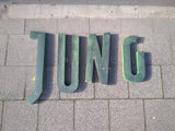 Schriftzug "JUNG"aus grünen Metallbuchstaben